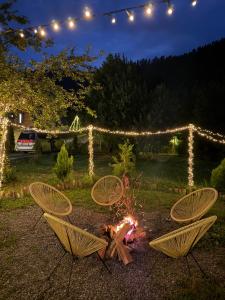 a fire in a yard with three chairs and lights at Landhaus Borjomi in Borjomi