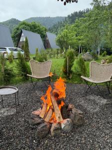 a fire pit in a yard with two chairs at Landhaus Borjomi in Borjomi +64 photos