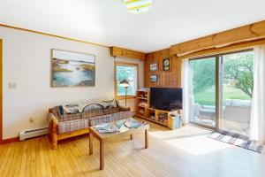 a living room with a couch and a tv at Waterfront stay with scenic deck, grill, smart TVs, shore access - dog-friendly in Penobscot