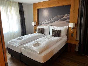 a bedroom with a large bed with a wooden headboard at Alpine Apartment Andermatt in Andermatt