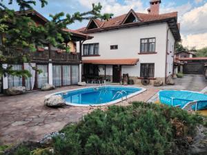 a swimming pool in front of a house at Къща за гости Бащин дом in Apriltsi