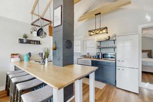 a kitchen with blue cabinets and a large kitchen island at Charming cottage with a spacious deck overlooking the Megunticook River in Camden