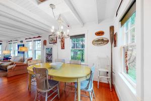 a dining room with a yellow table and chairs at Waterfront dog-friendly cottage with amazing views, deck, grill, & washer/dryer in Cushing +30 photos