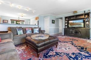 a living room with a couch and a tv at Charming home with stunning bay views, sunroom, gazebo, deck, & grill in Trenton