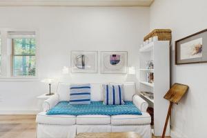 a white living room with a white couch with blue pillows at Charming coastal cottage with firepit and easy beach access in Rockport