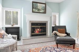 a living room with a fireplace and a chair at Charming home with stunning bay views, sunroom, gazebo, deck, & grill in Trenton