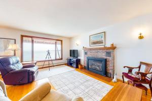 a living room with a couch and a fireplace at Waterfront home with beautiful bay views - near shops & dining in Owls Head