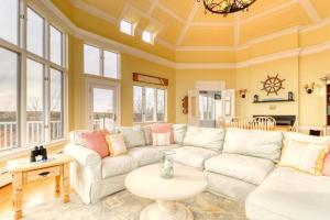 a living room with a white couch and a table at Bayfront home with 270-degree views, large deck & porch - near Popham Beach in Phippsburg