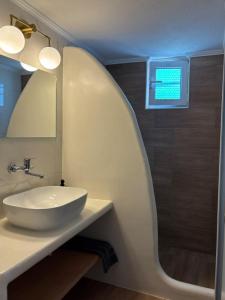 a bathroom with a sink and a mirror at Enalia Apartments in Korissia