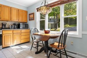 a kitchen with a table and chairs and a chandelier at Charming home with stunning bay views, sunroom, gazebo, deck, & grill in Trenton +27 photos