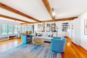 un soggiorno con divani blu e un tavolo di Elegant home right in town with gorgeous water view, deck & interior a Wiscasset