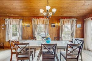 a dining room with a white table and chairs at Dog-friendly, bayfront home - gorgeous ocean views, private balcony & fireplace in East Boothbay