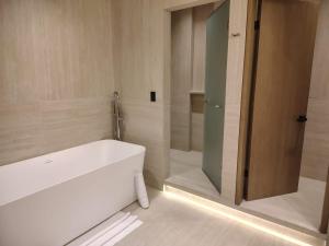 ein Badezimmer mit Badewanne und Glastür in der Unterkunft Antaris Cintermex in Monterrey