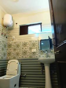 a small bathroom with a toilet and a sink at RCA Homestay in Dharmsāla