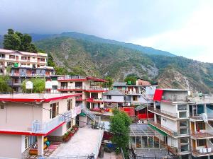 a group of buildings with mountains in the background at RCA Homestay in Dharmsāla