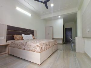 a bedroom with a bed and a ceiling fan at RCA Homestay in Dharmsāla