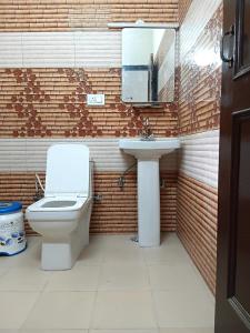 a bathroom with a toilet and a sink at RCA Homestay in Dharmsāla +17 photos