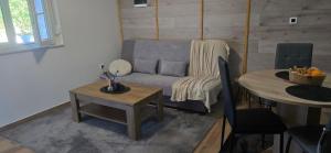 a living room with a couch and a table at Studio Apartment Loly in Nedeščina +3 photos