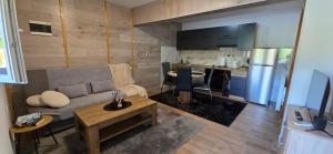a living room with a couch and a table and a kitchen at Studio Apartment Loly in Nedeščina