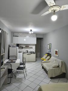 a kitchen and living room with a couch and a table at Studio Centro Floripa 02 in Florianópolis