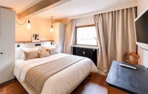 a bedroom with a large bed and a window at L'Ecrin de Jade - Valloire in Valloire