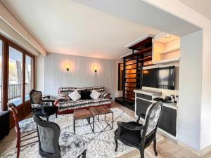 a living room with a couch and a table and chairs at L'Ecrin de Jade - Valloire in Valloire