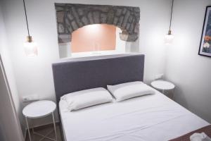 a small room with a bed with two stools at Akrolithos apartments ground floor in Platy