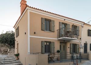 a large house with a balcony and stairs at Akrolithos apartments ground floor in Platy