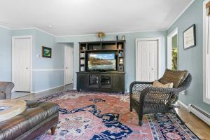 a living room with a couch and a television at Charming home with stunning bay views, sunroom, gazebo, deck, & grill in Trenton