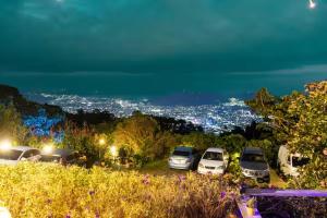 a group of cars parked in a parking lot at night at Las Cabañitas, el boqueron in San Salvador +1 photo