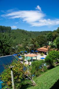 a resort with a swimming pool and a mountain at Hotel Rural Vale das Nascentes in Salesópolis