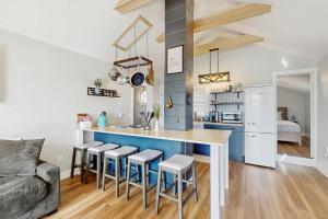 a kitchen with a blue counter and stools at Charming cottage with a spacious deck overlooking the Megunticook River in Camden