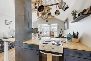 a kitchen with a stove and a counter top at Charming cottage with a spacious deck overlooking the Megunticook River in Camden +11 photos