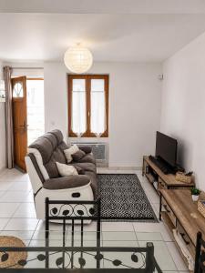 a living room with a couch and a tv at L'Escale de Bonny in Bonny-sur-Loire