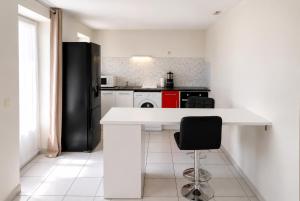 a kitchen with a white counter and a black refrigerator at L'Escale de Bonny in Bonny-sur-Loire +4 photos
