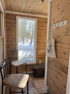 a room with two chairs and a window in a cabin at Pura Vida | A Calm Apt Escape Minutes from Camden in Camden