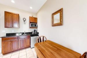 a kitchen with a wooden table and a sink and a mirror at Comfortable Suite in Downtown Northeast Harbor w/ WiFi & AC - Walk to the Water in Northeast Harbor +8 photos