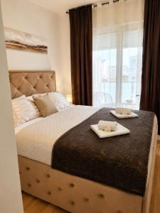 a bedroom with a bed with two dishes on it at Modern New Apartment Miss T I Free Parking I Great Location in Podgorica
