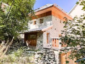 an old stone house with wooden doors and trees at Chalet La Tourelle - Valloire in Valmeinier