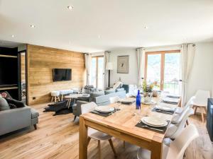 a living room with a table and chairs and a couch at L'Étoile D'or - Valloire in Valloire