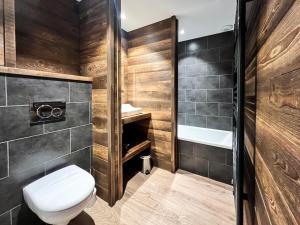 a bathroom with a toilet and a bath tub at L'Étoile D'or - Valloire in Valloire +8 photos