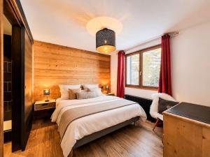 a bedroom with a large bed with a wooden wall at L'Étoile D'or - Valloire in Valloire