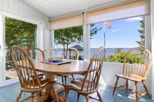 a dining room with a table and chairs and a window at Charming home with stunning bay views, sunroom, gazebo, deck, & grill in Trenton