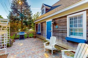 una casa con due sedie sedute su un patio di mattoni di Elegant home right in town with gorgeous water view, deck & interior a Wiscasset