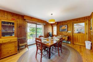 a dining room with a table and chairs at Waterfront stay with scenic deck, grill, smart TVs, shore access - dog-friendly in Penobscot