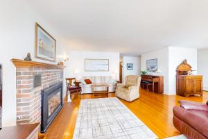 a living room with a fireplace and a couch at Waterfront home with beautiful bay views - near shops & dining in Owls Head