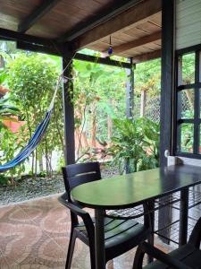 a hammock on a porch with a table and chairs at BlueBayou.capurgana in Capurganá