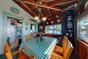 a dining room with a table and chairs in a house at Spacious Waterfront Estate & Cabins W/ Porch, Fireplace, Kayaks & Free WiFi in Brunswick