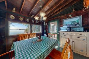 a dining room with a table with a girl sitting on it at Spacious Waterfront Estate & Cabins W/ Porch, Fireplace, Kayaks & Free WiFi in Brunswick