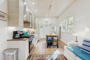a kitchen with a couch and a stove top oven at Charming coastal cottage with firepit and easy beach access in Rockport +11 photos